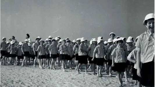 Bambini di una colonia marina a passeggio sulla spiaggia di Rimini nel 1963